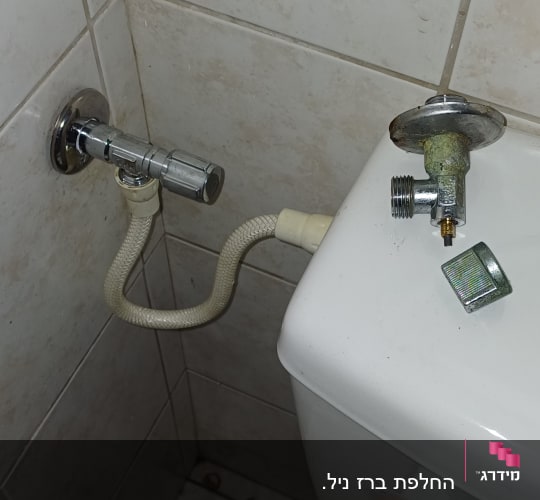 ברז וחיבורי מים ליד אסלה בשירותים